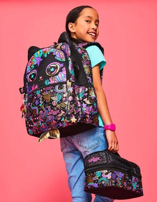 Young girl wearing Smiggle 15-inch black cat school backpack with matching lunchbox attached